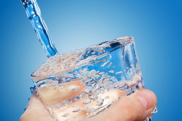A clear glass being filled with clean drinking water